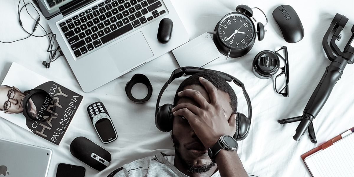 Мужчина лежит перед множеством гаджетов