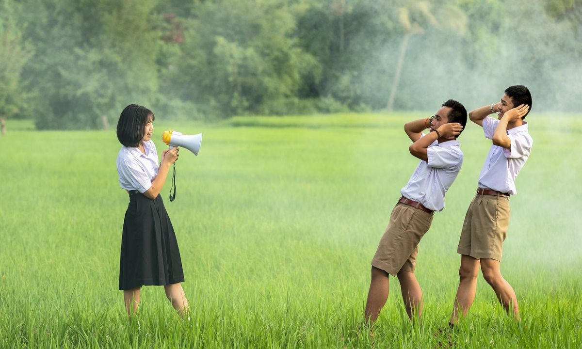 men covering their ears at a shouting lady