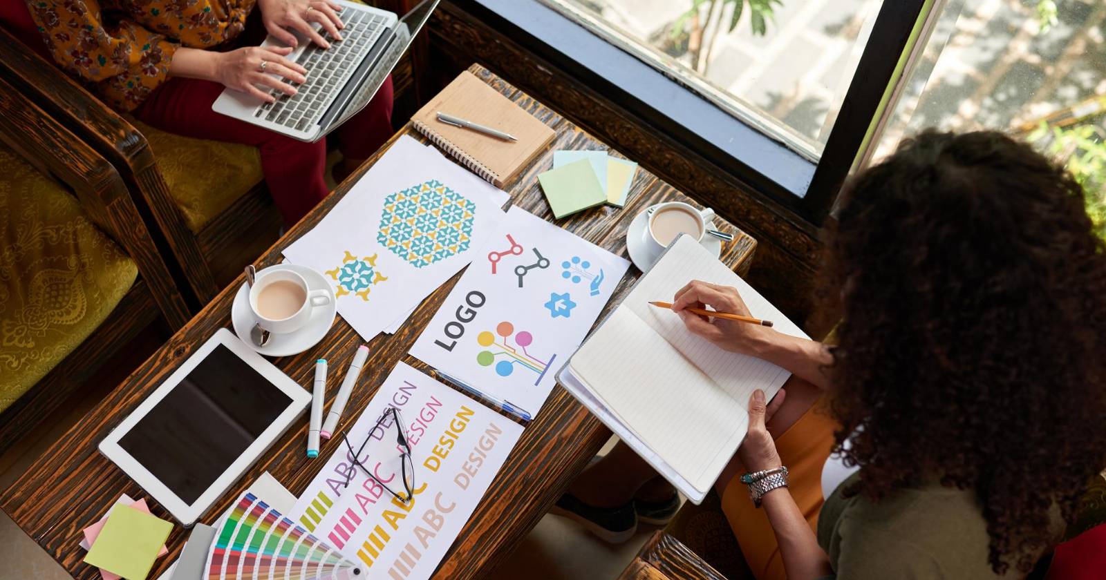 Двое дизайнеров работают над проектом логотипа