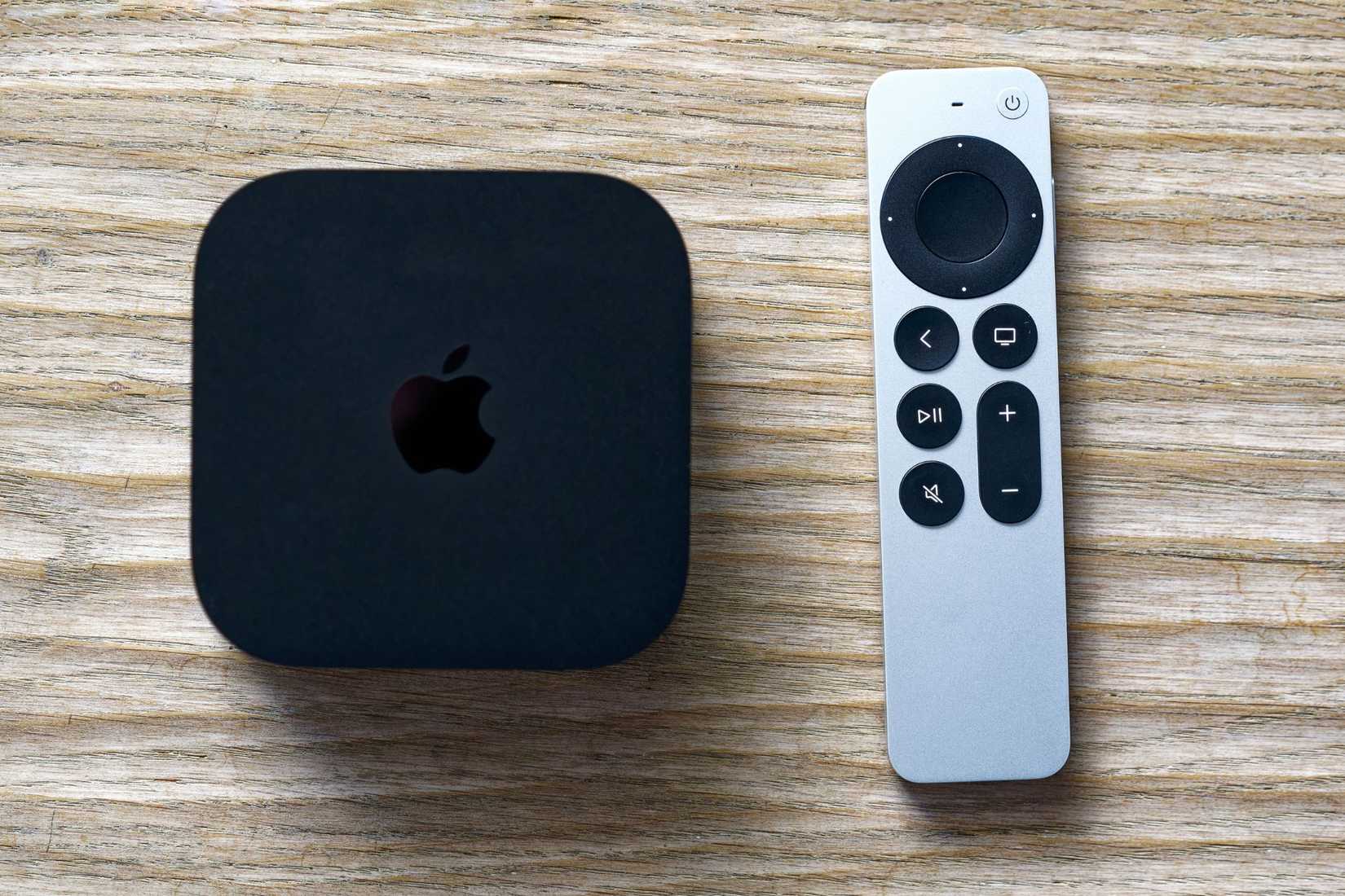 черный медиаплеер Apple TV 4K и пульт на белом фоне