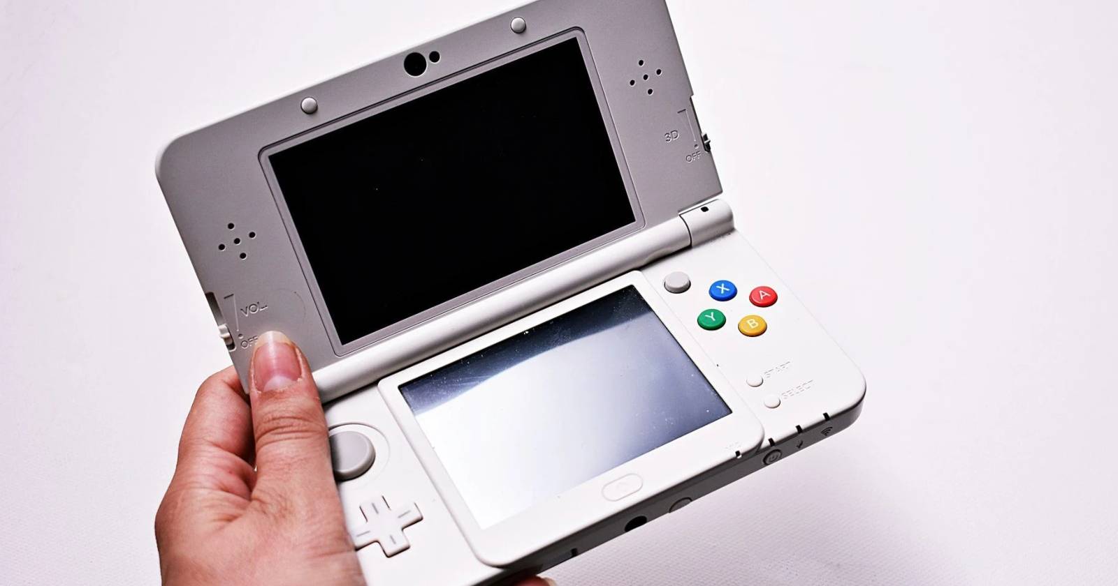 nintendo 3ds being held screen off silver