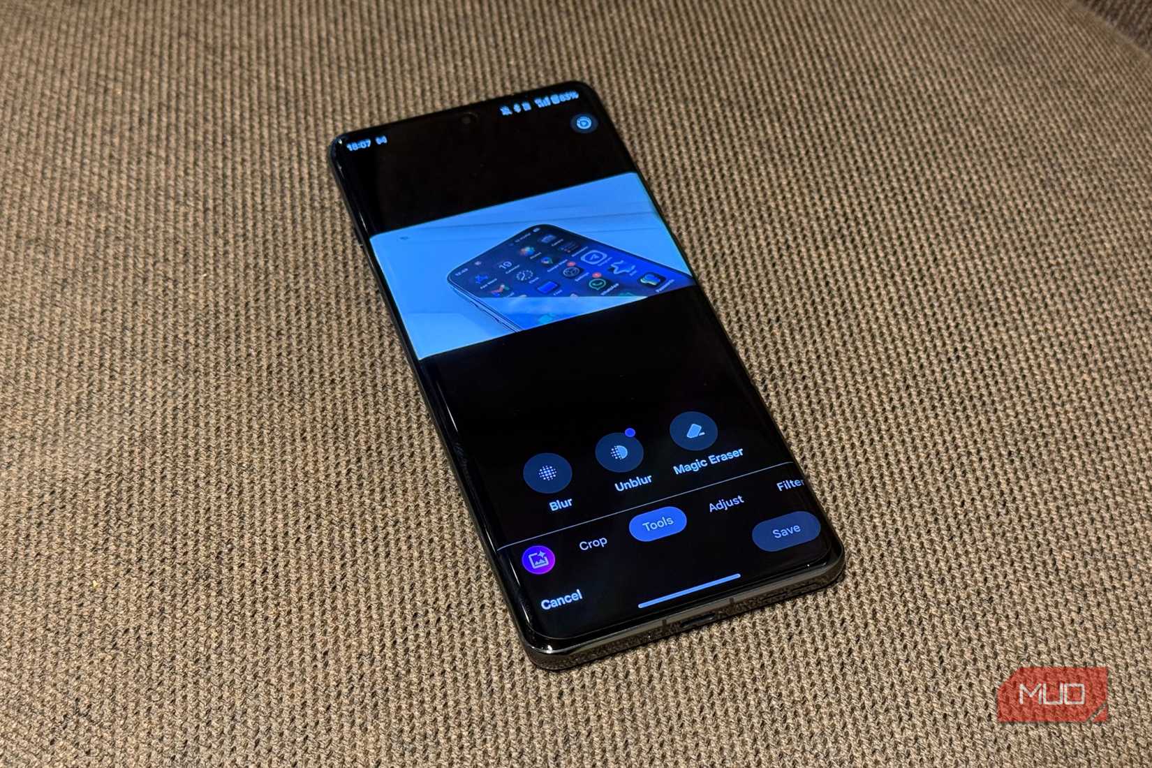 смартфон на текстильной поверхности с открытым меню редактирования google photos, показывающим вкладку tools