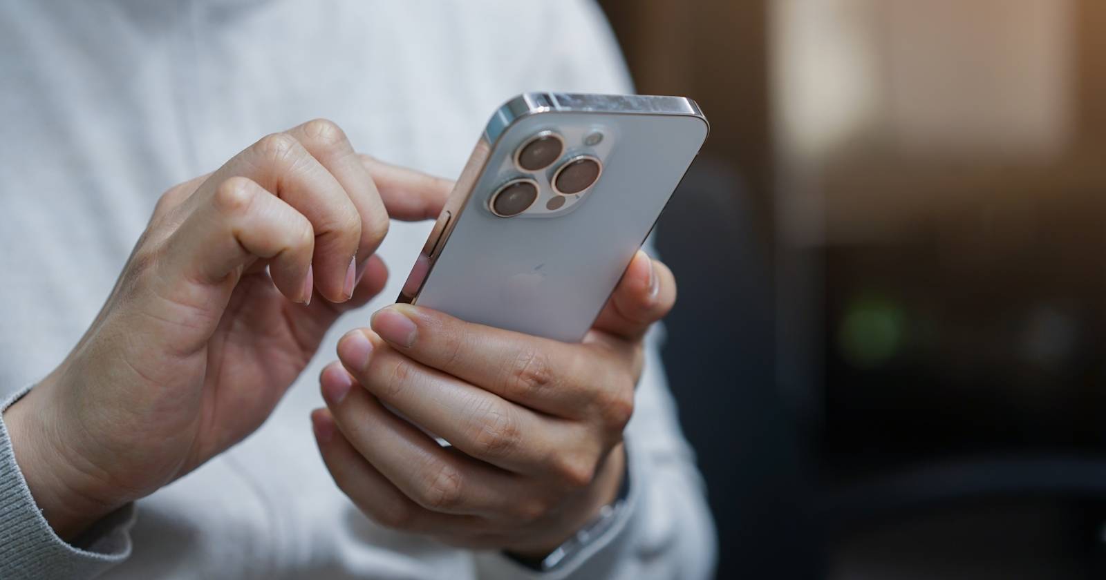 человек прикасается к iPhone 13 Pro Max