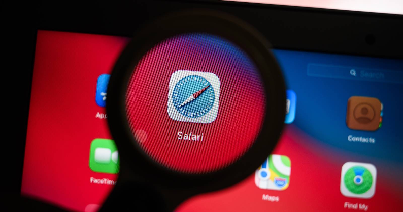 Лупа на фоне экрана MacBook с открытой страницей