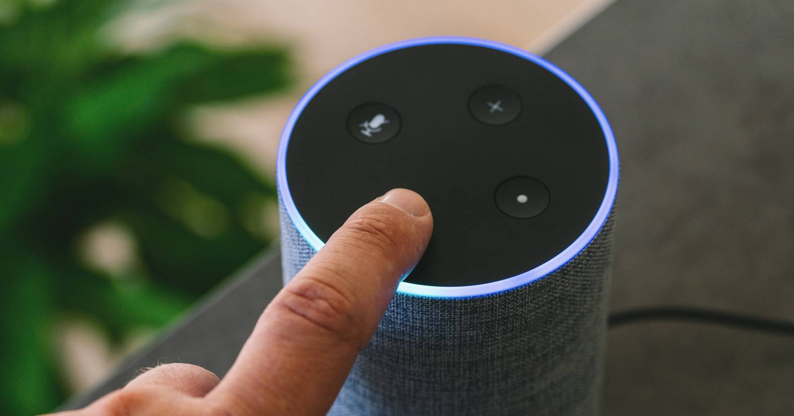 Колонка Amazon Echo: палец нажимает кнопку на устройстве