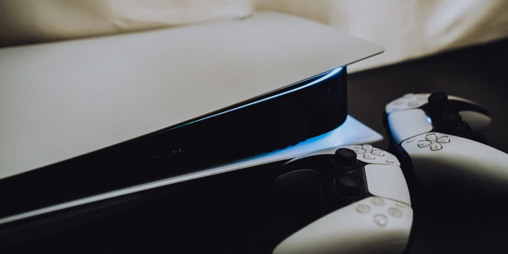 PlayStation 5 с двумя контроллерами на столе