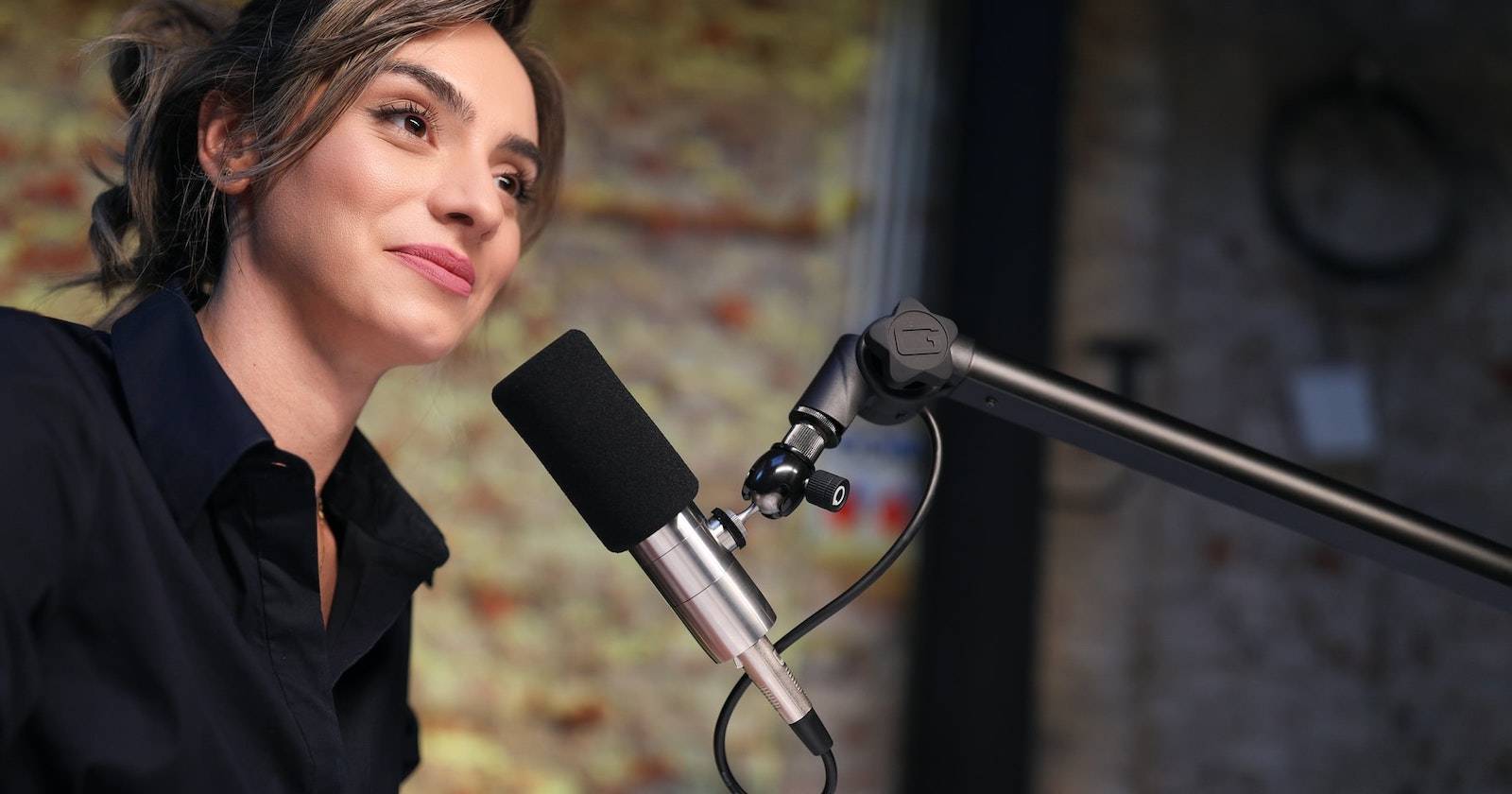 Женщина говорит в микрофон, направленный на неё.