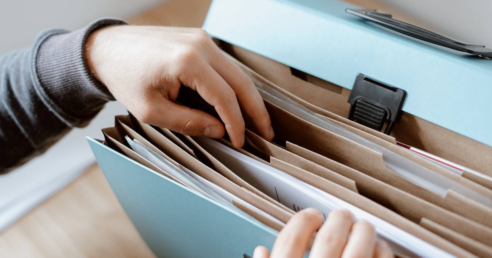 человек вытаскивает один файл из стопки документов