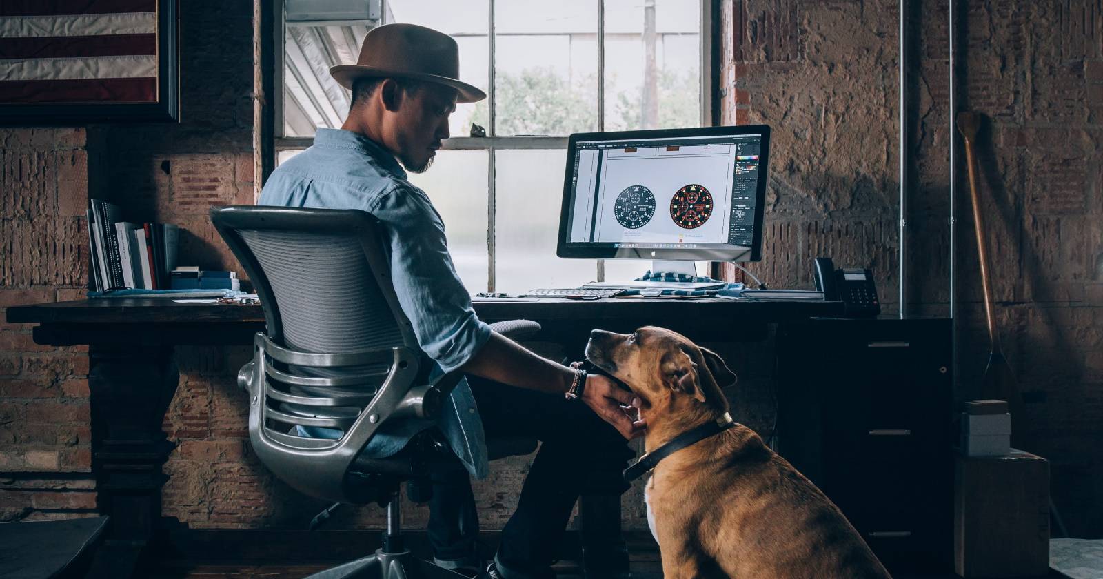 мужчина работает из дома и гладит собаку