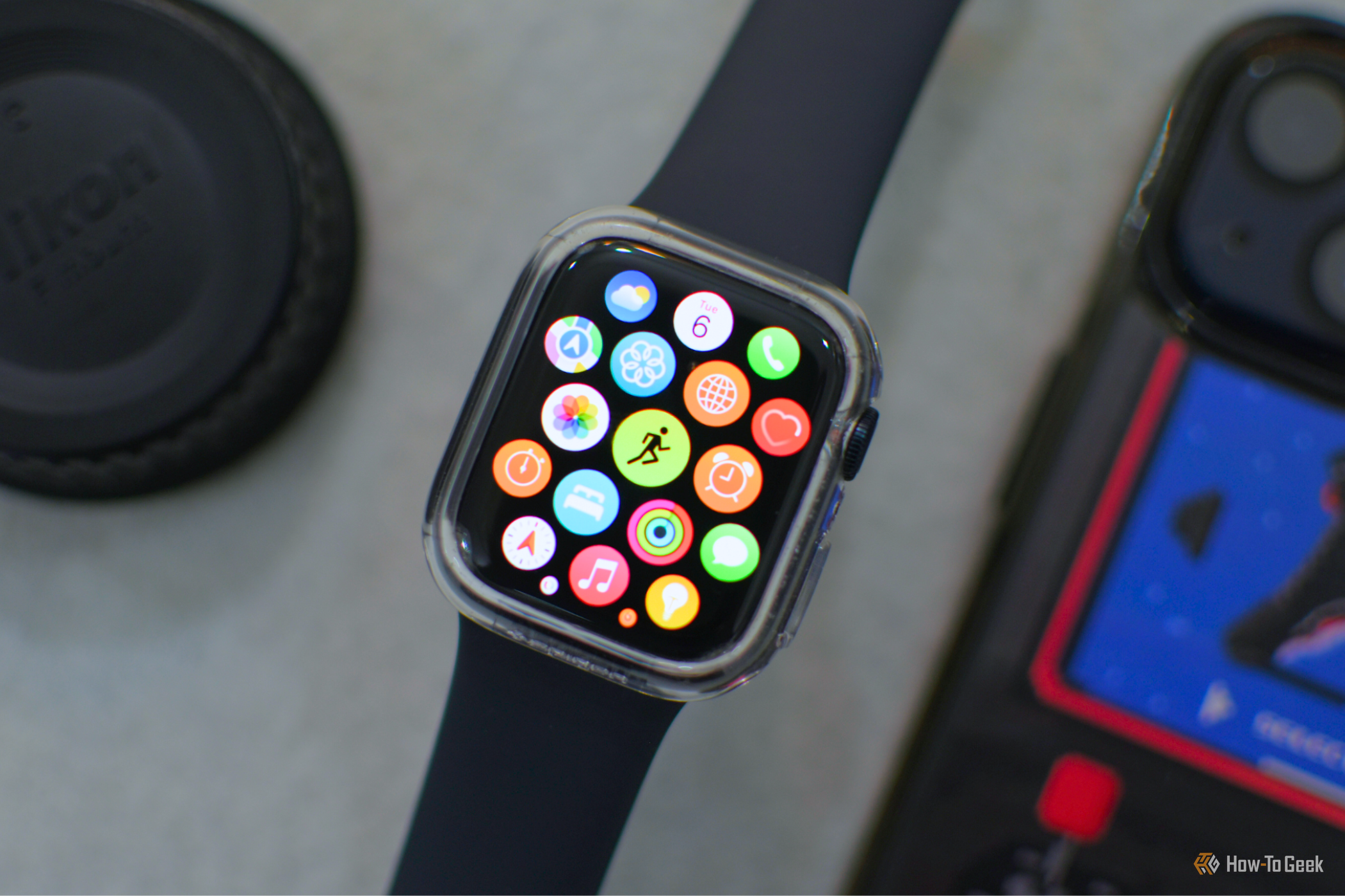 Apple Watch на сером фоне рядом с iPhone