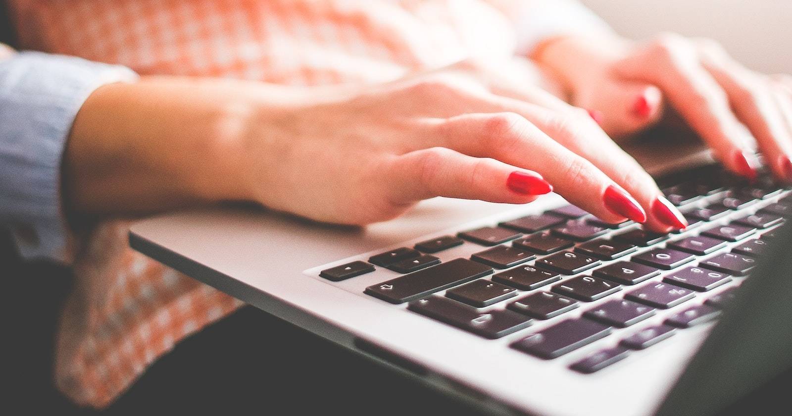 Женщина печатает на клавиатуре ноутбука