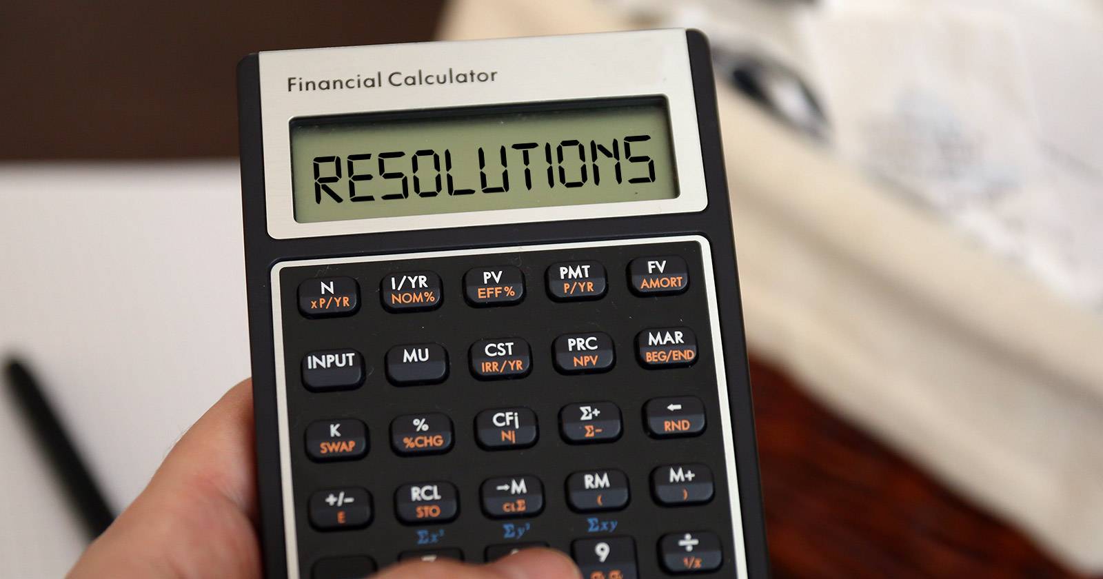 Человек записывает финансовые цели в блокнот