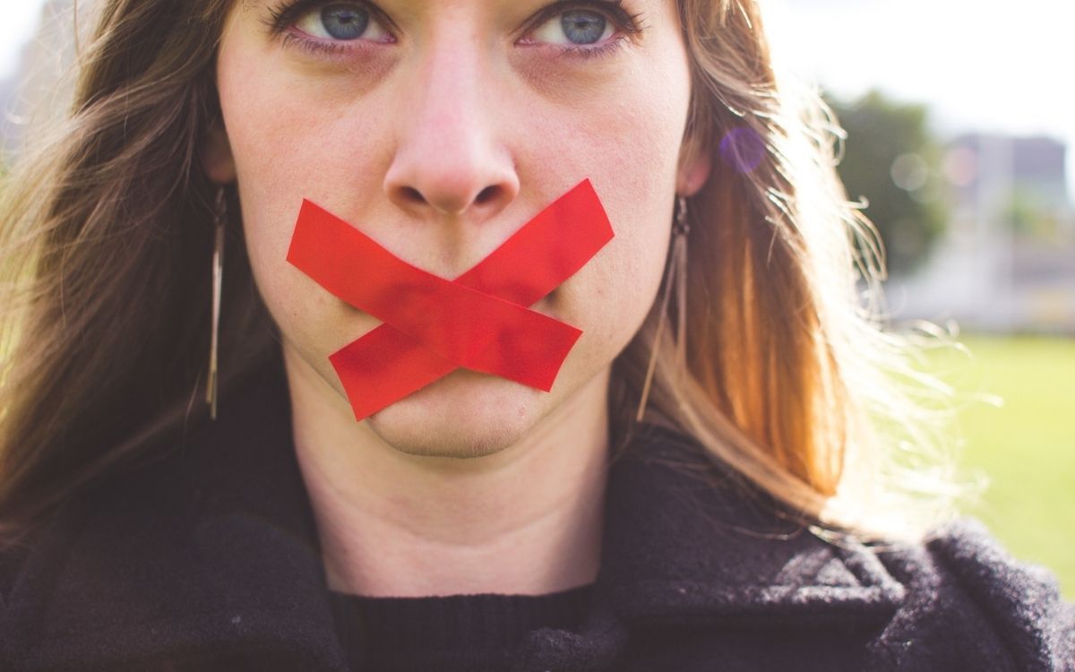 Женщина с красной липкой лентой на рту