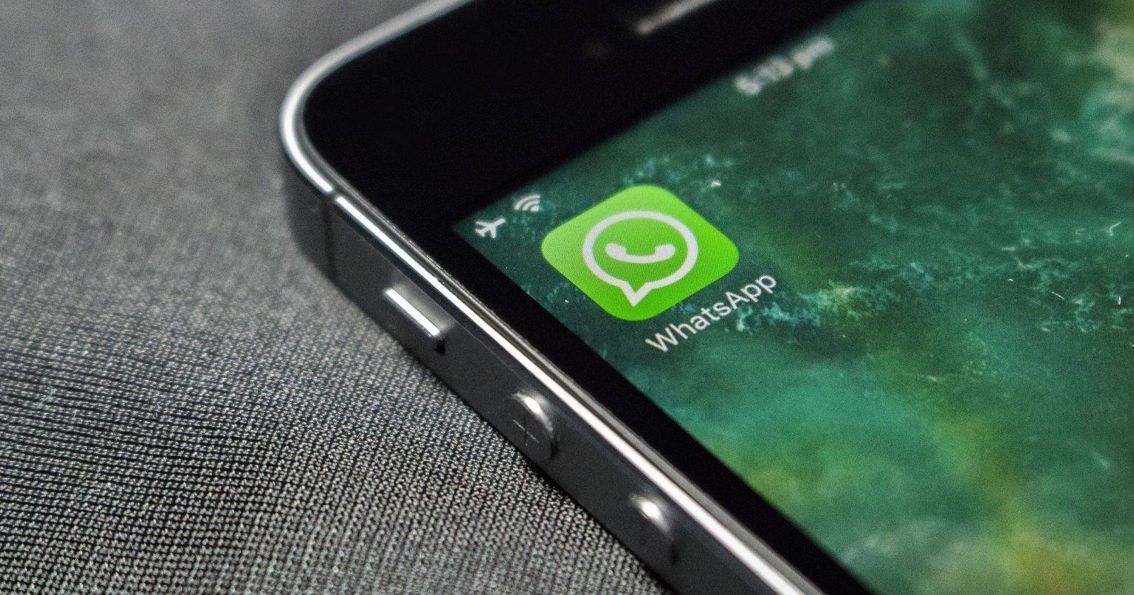Смартфон с открытым приложением WhatsApp и логотипом на экране