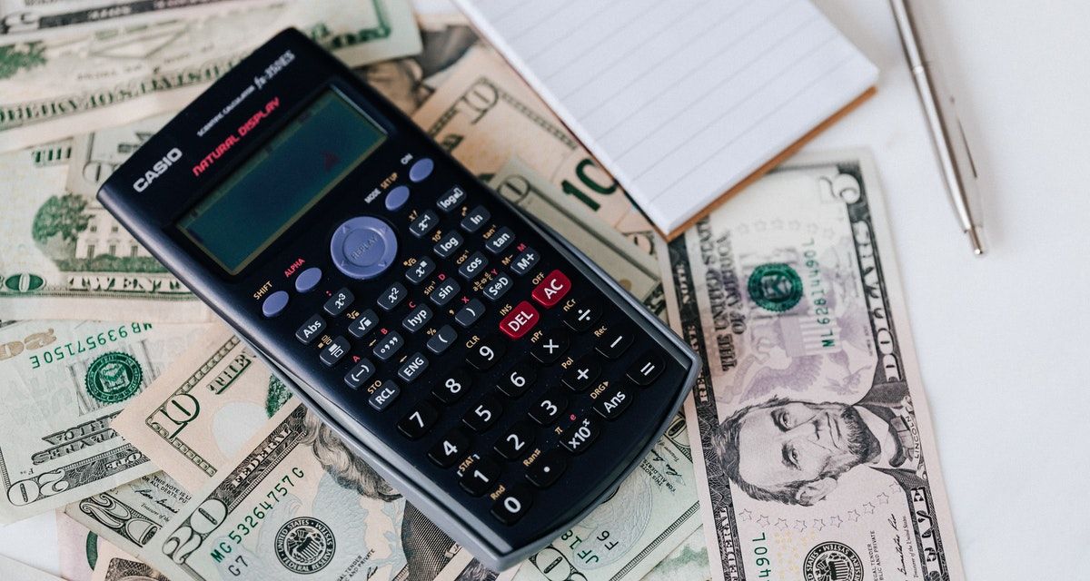 calculator and notepad with bills