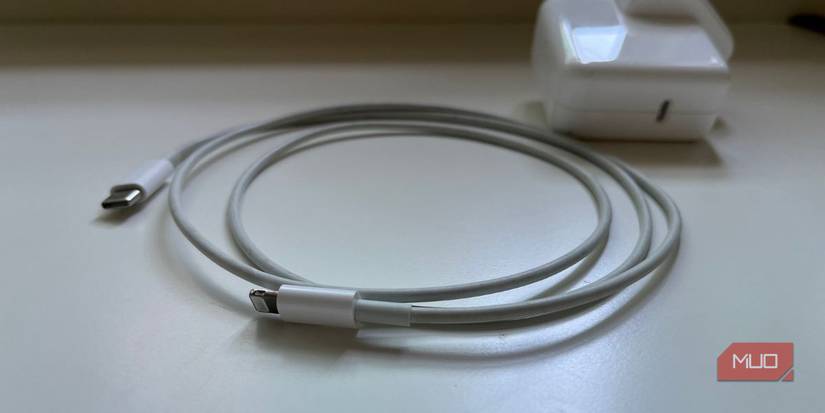 Кабель Lightning и сетевой адаптер рядом с iPhone