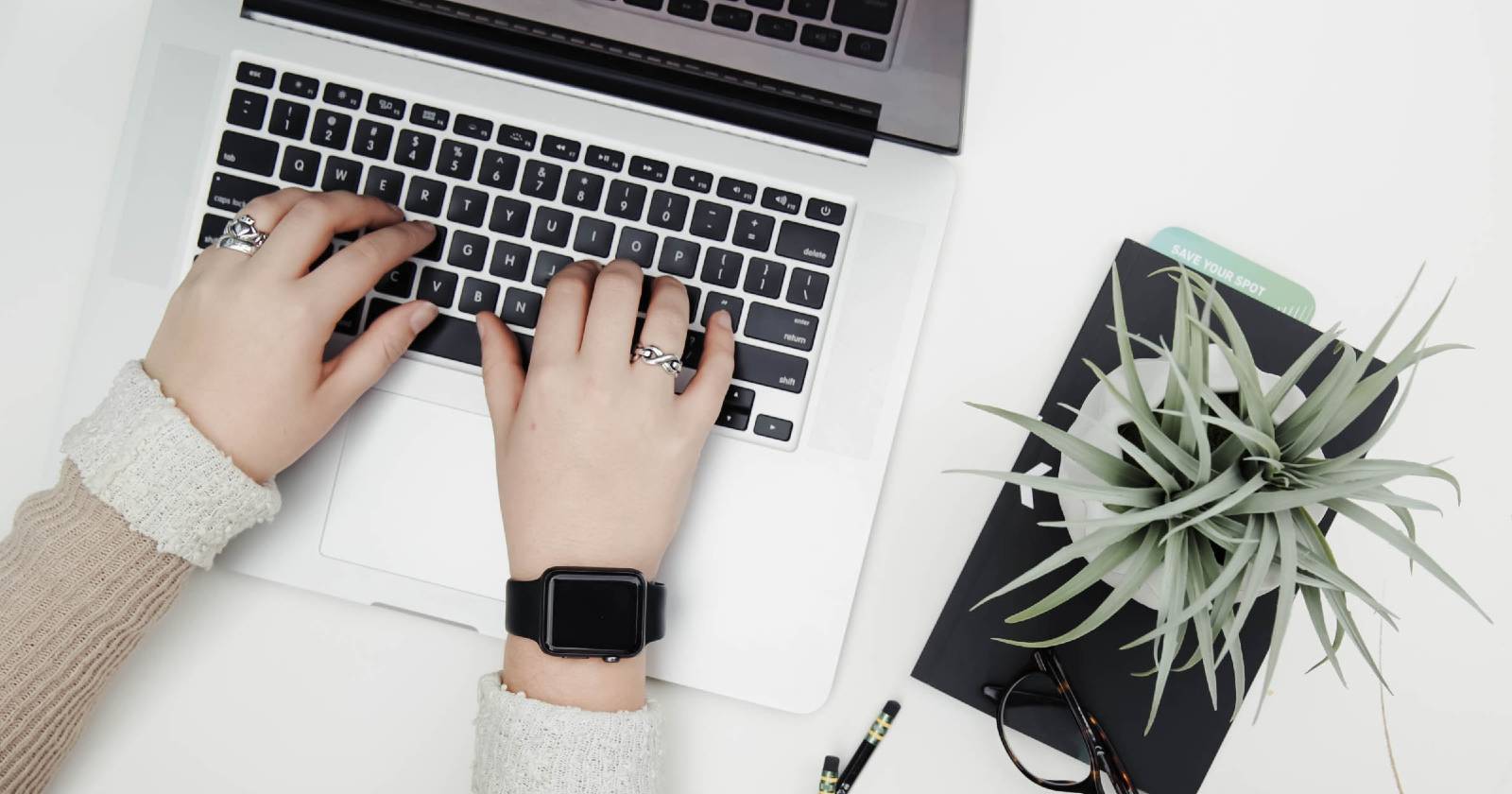 Руки печатают на MacBook на рабочем столе