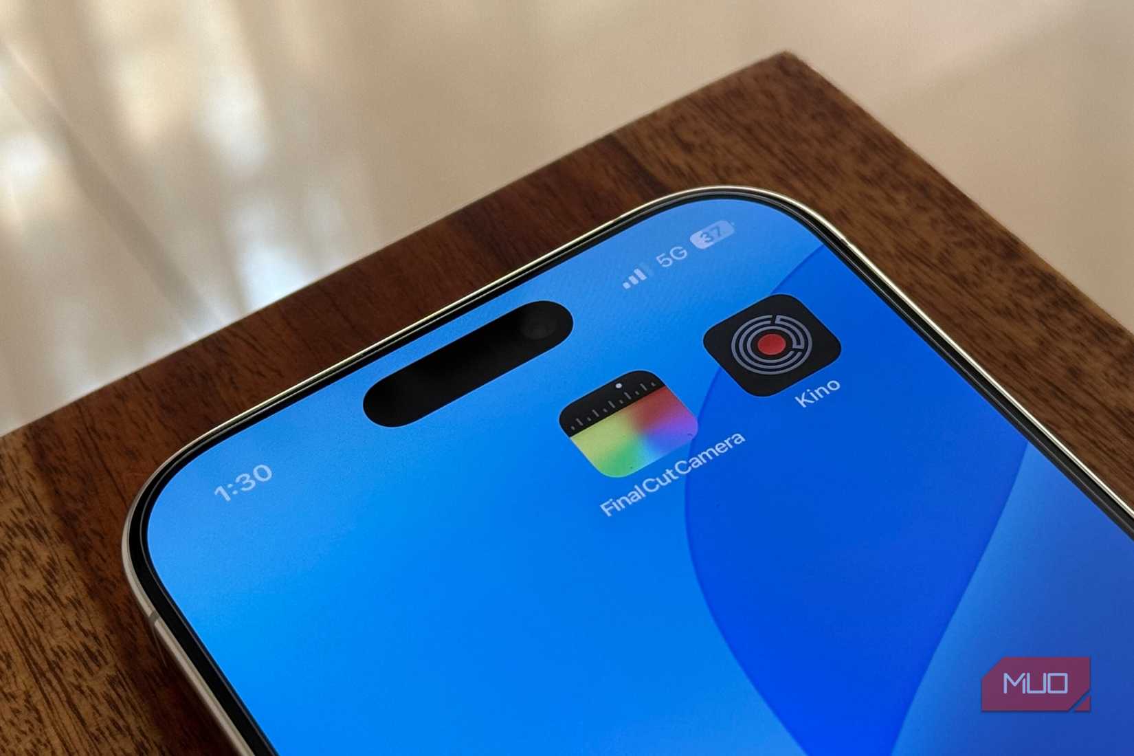 iPhone 16 Pro на столе с иконками камерных приложений на домашнем экране