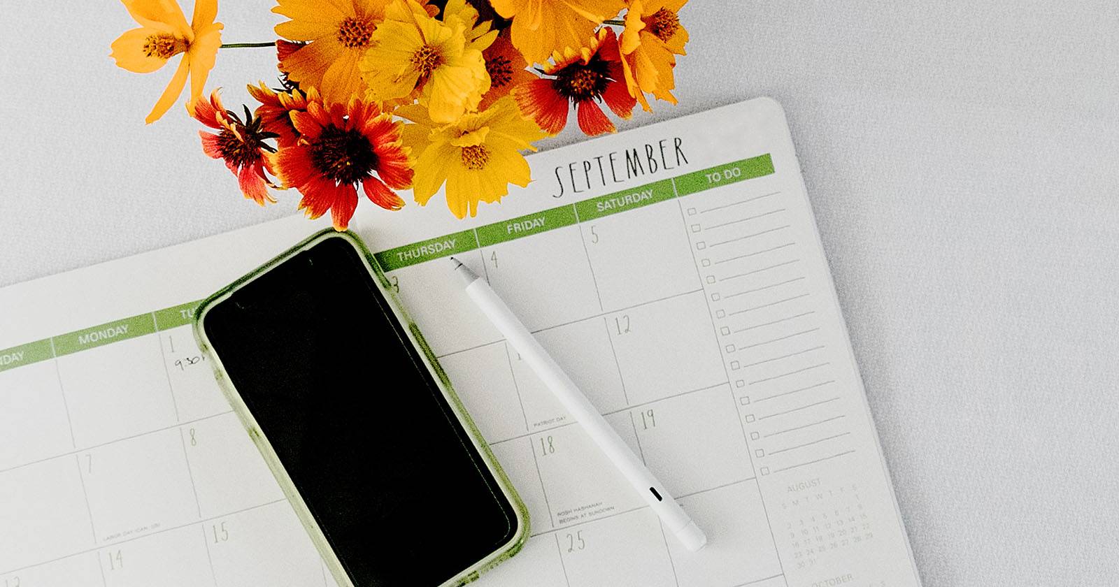 Плоская композиция с планером, ручкой и смартфоном