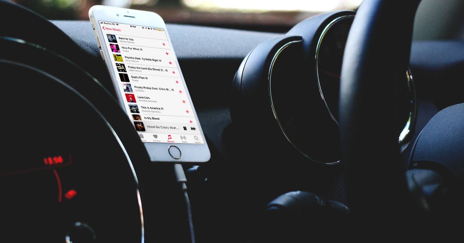 Смартфон, закреплённый в автомобиле, показывает приложение Apple Music