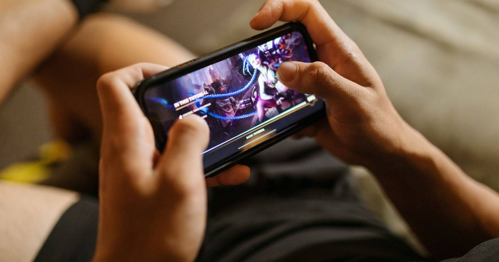 Крупный план: человек играет в League of Legends на мобильном устройстве