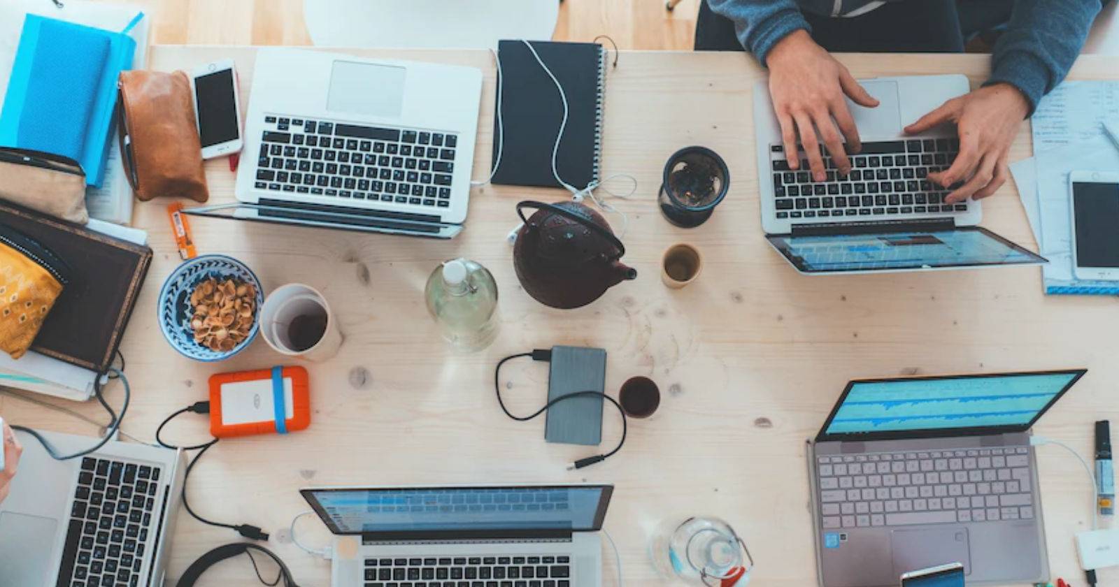 Вид сверху на несколько ноутбуков, лежащих на столе