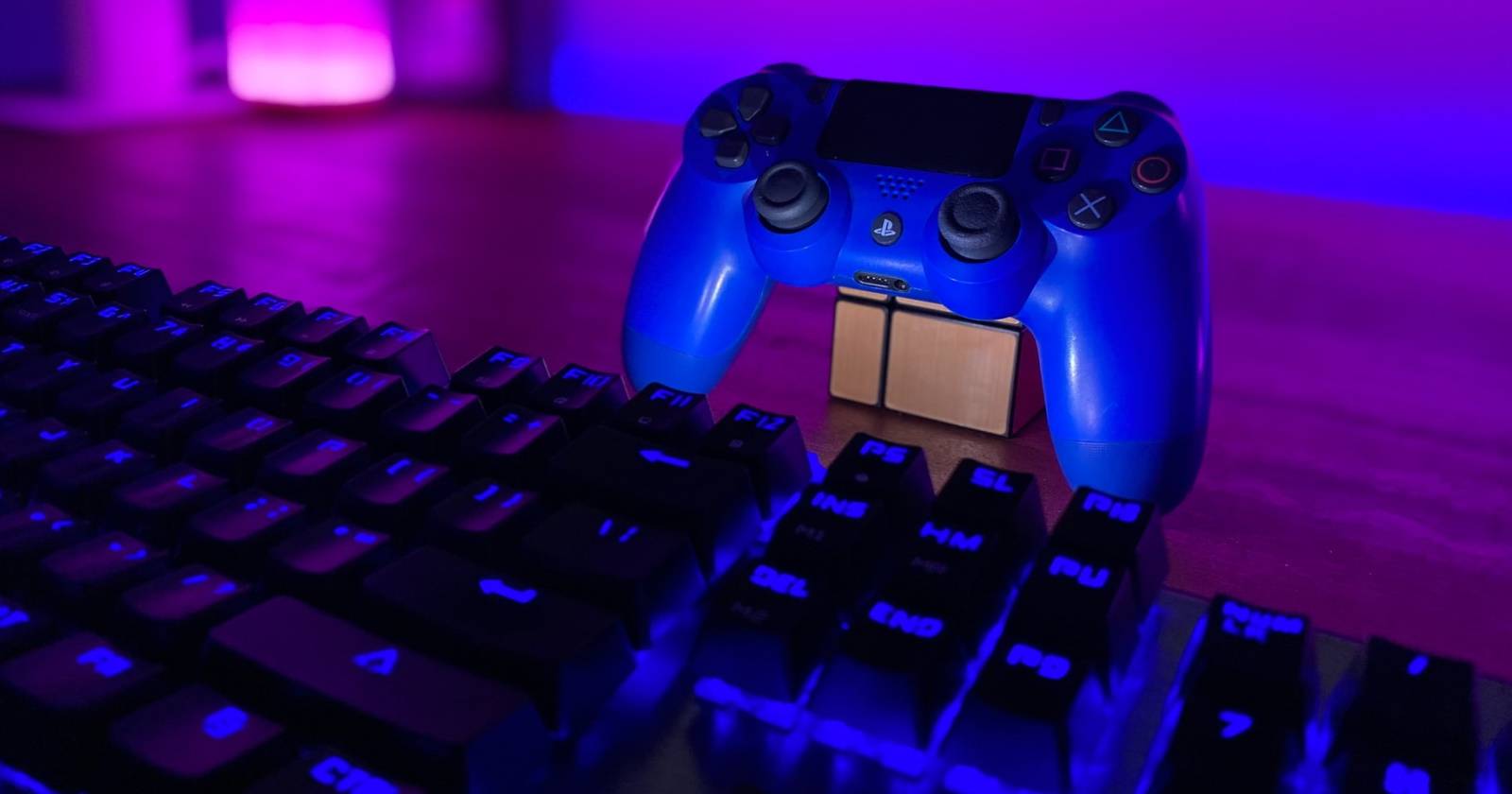 геймпад PlayStation рядом с клавиатурой компьютера