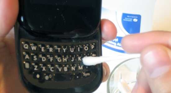 Чистка вокруг кнопок с помощью ватной палочки