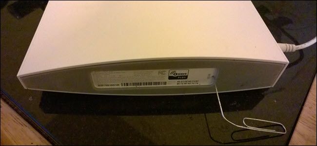 Wink Hub 2 с бумажной скрепкой, вставленной в отверстие для сброса