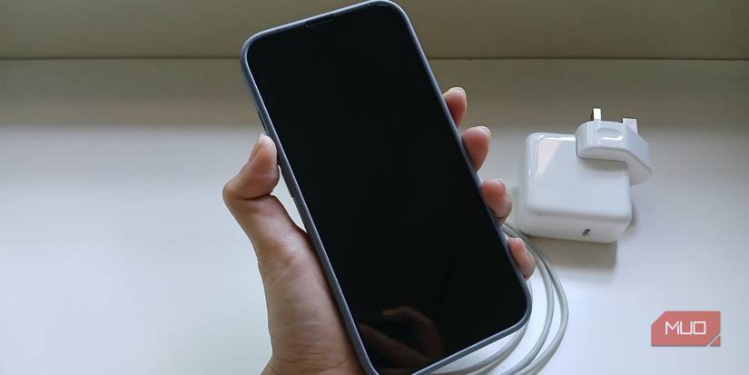 Рука держит iPhone с чёрным экраном