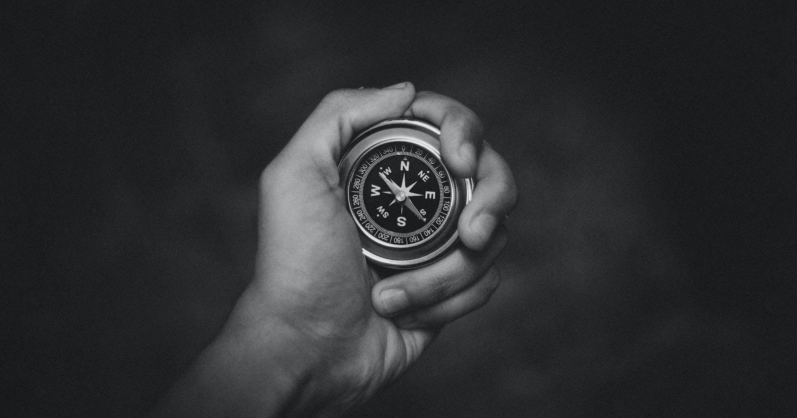 Крупный план руки, держащей аналоговый компас