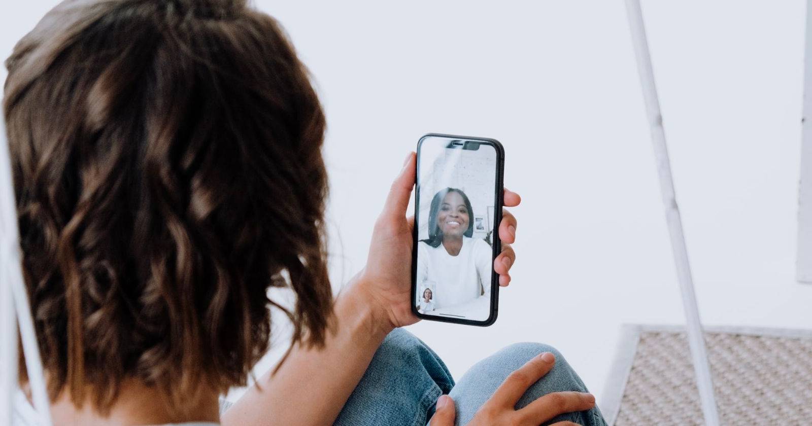 человек держит iPhone и участвует в видеозвонке