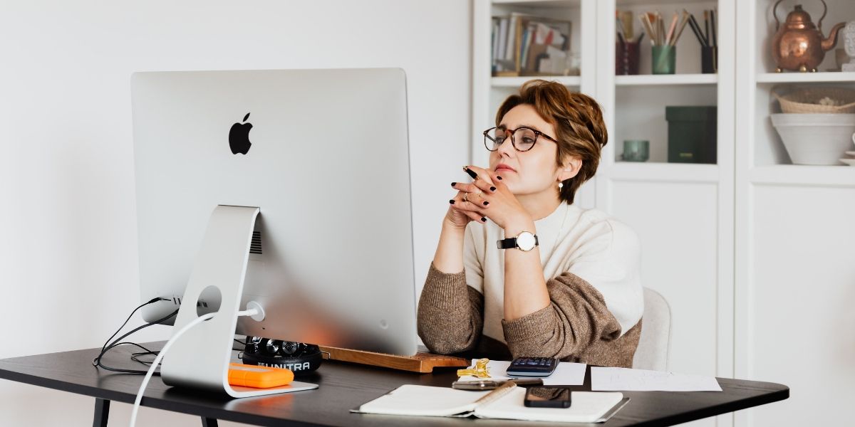 женщина вдумчиво читает информацию на экране компьютера