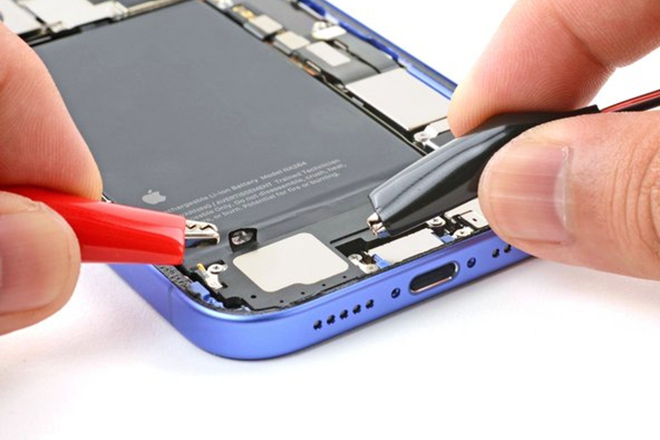 iFixIt: зажим для проверки напряжения рядом с телефоном.