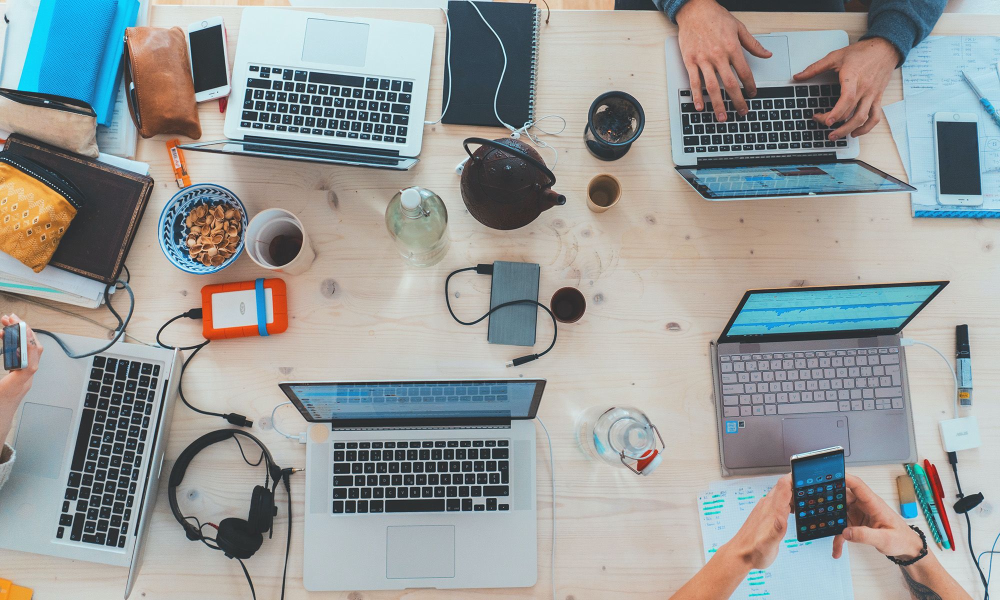 Multiple laptops and phones on a table
