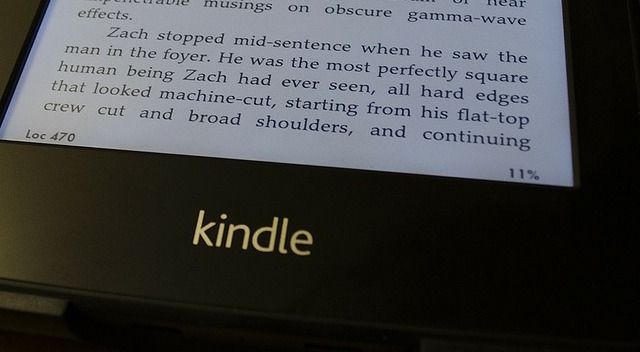 Человек читает Kindle со шкалой прогресса на экране