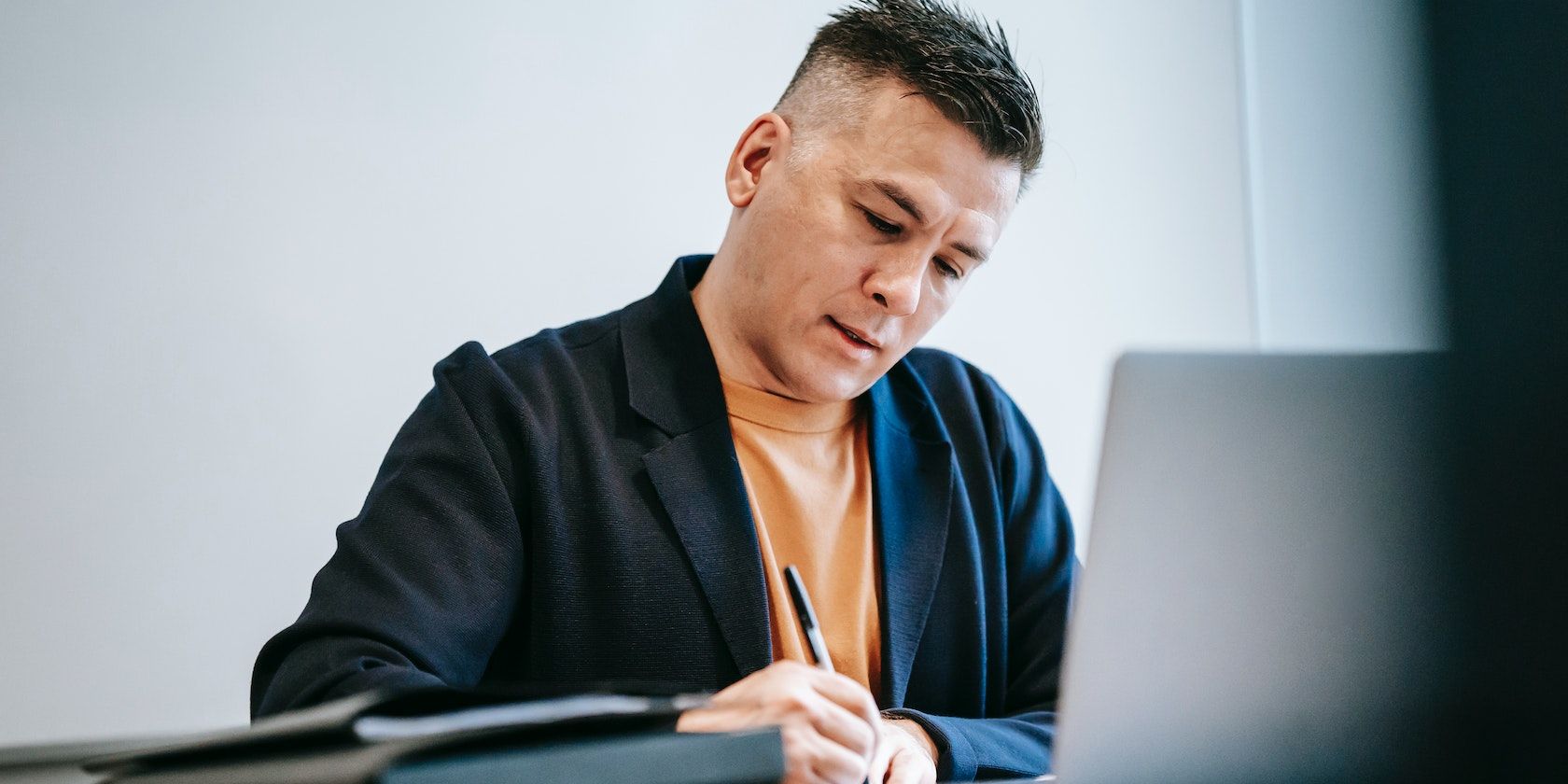 Мужчина пишет ручкой в блокноте