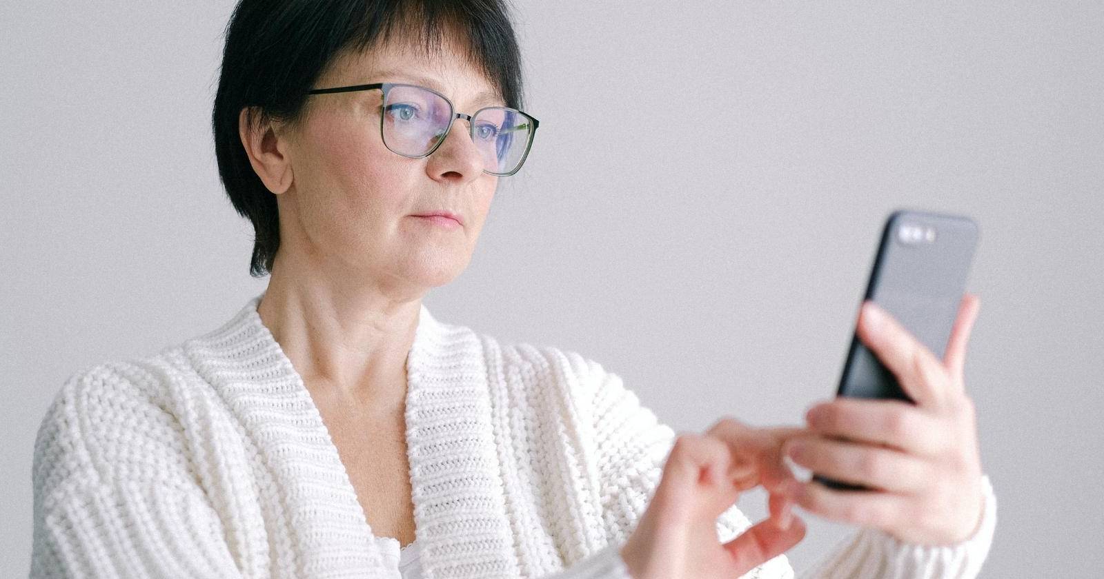 Пожилой человек использует iPhone