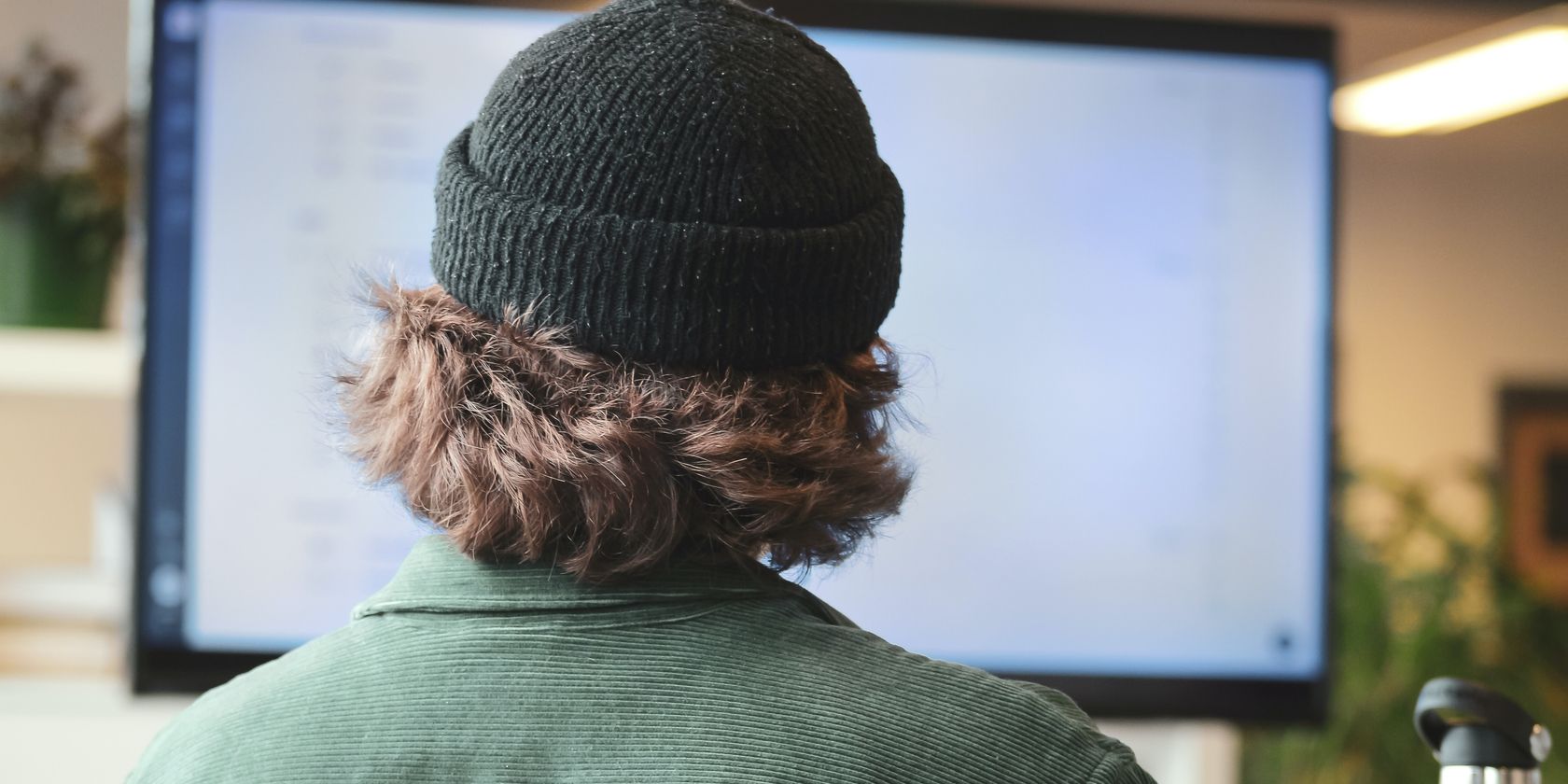 A Man Sitting At A Desk While Working On A Computer