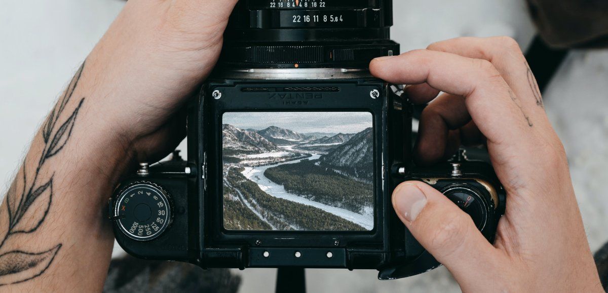Человек держит камеру с пейзажем на экране