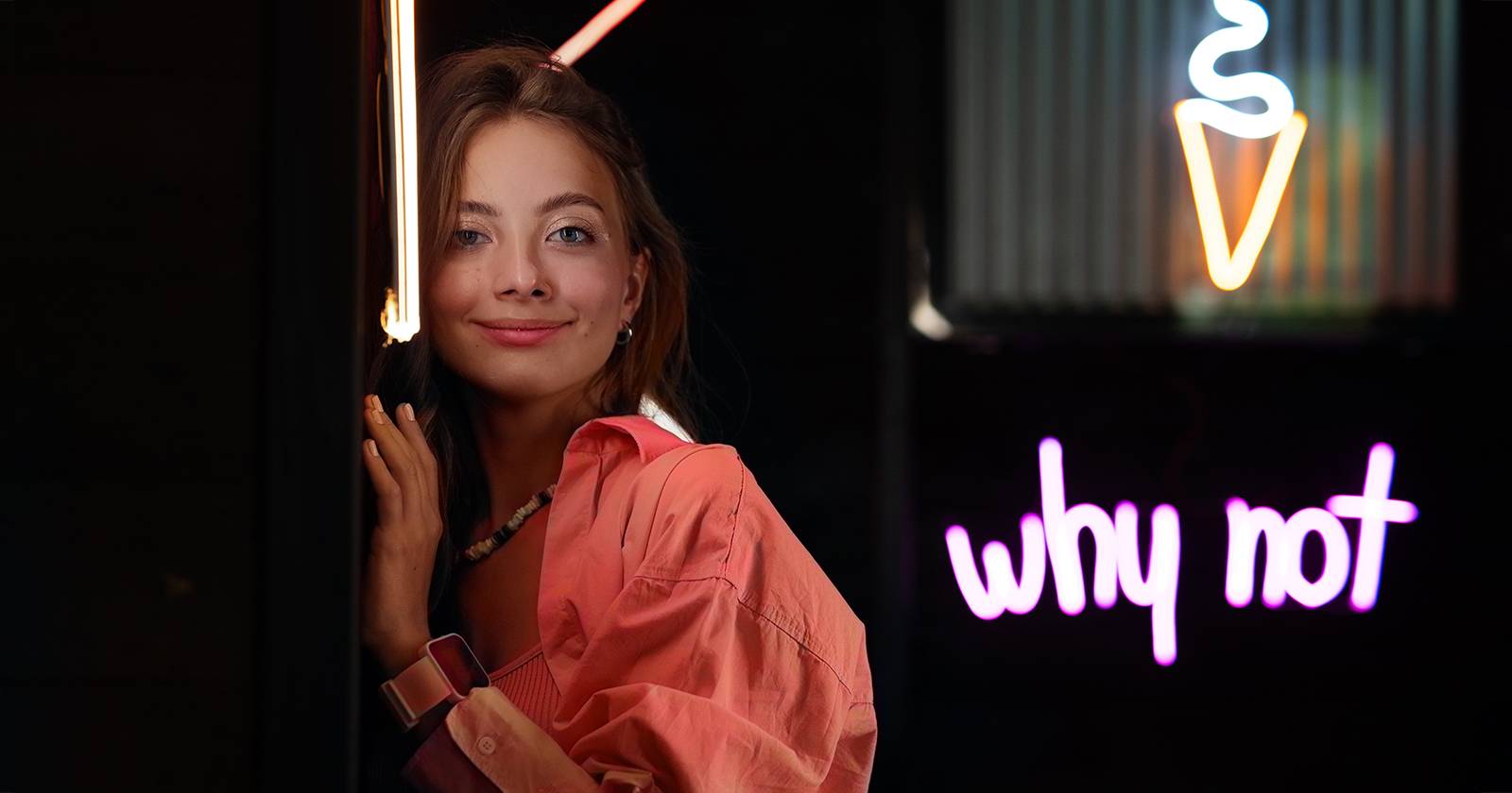 Женщина рядом с неоновой вывеской