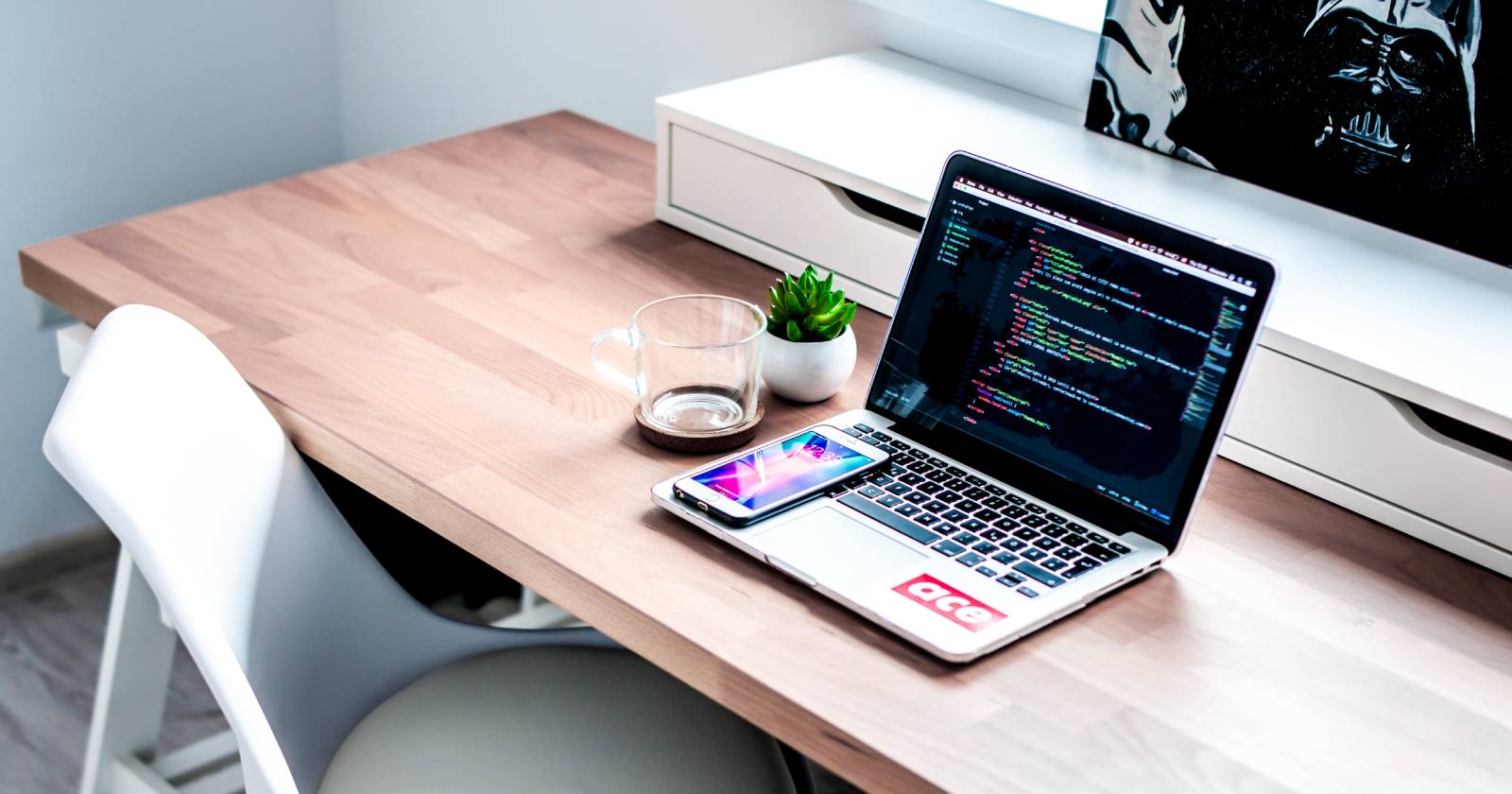 Смартфон на ноутбуке, лежащем на коричневом деревянном столе