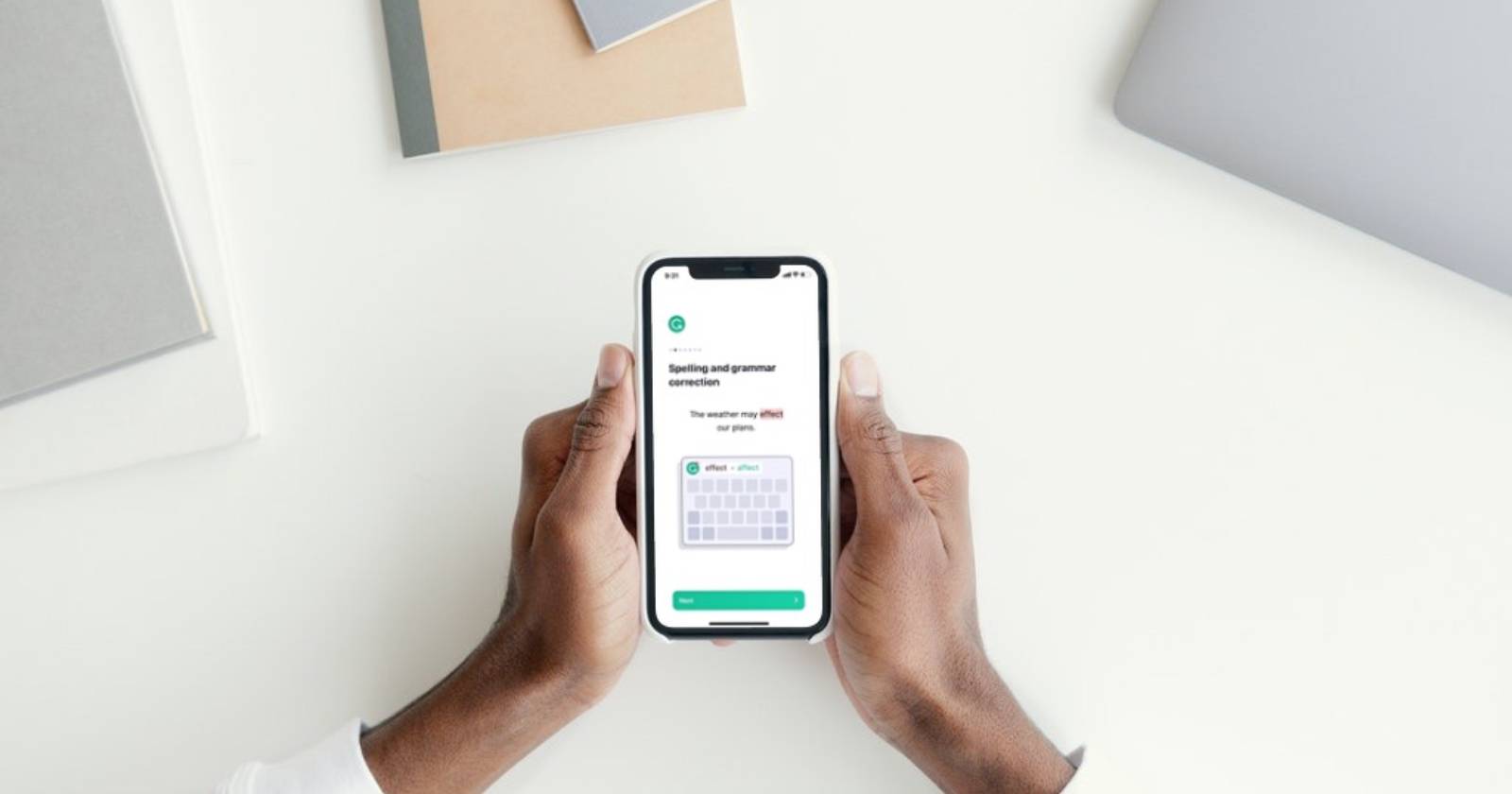 Мужчина держит iPhone с экраном, где показана настройка Grammarly