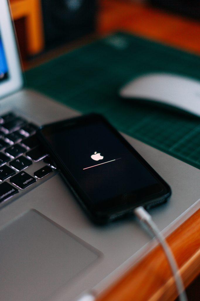 Человек обновляет iPhone через компьютер