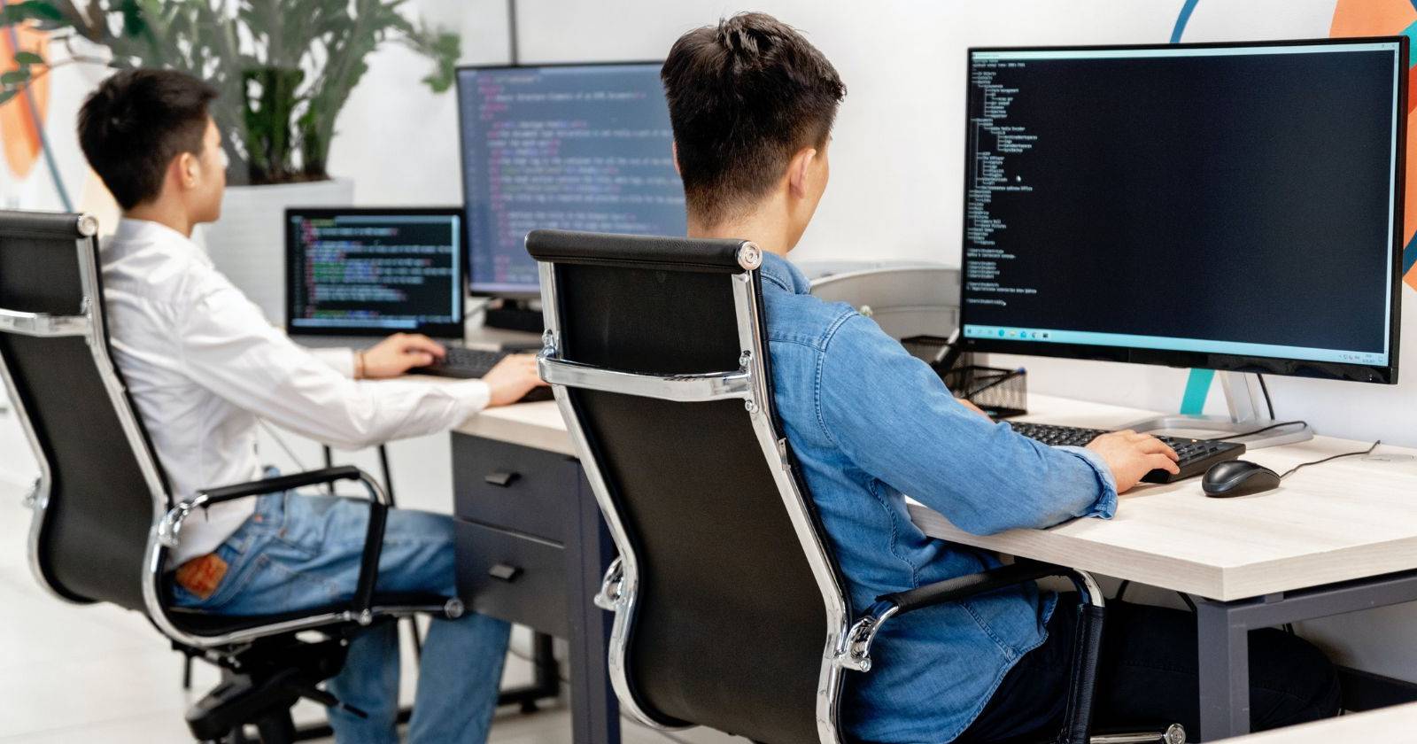 двое человек работают за ноутбуками в офисе