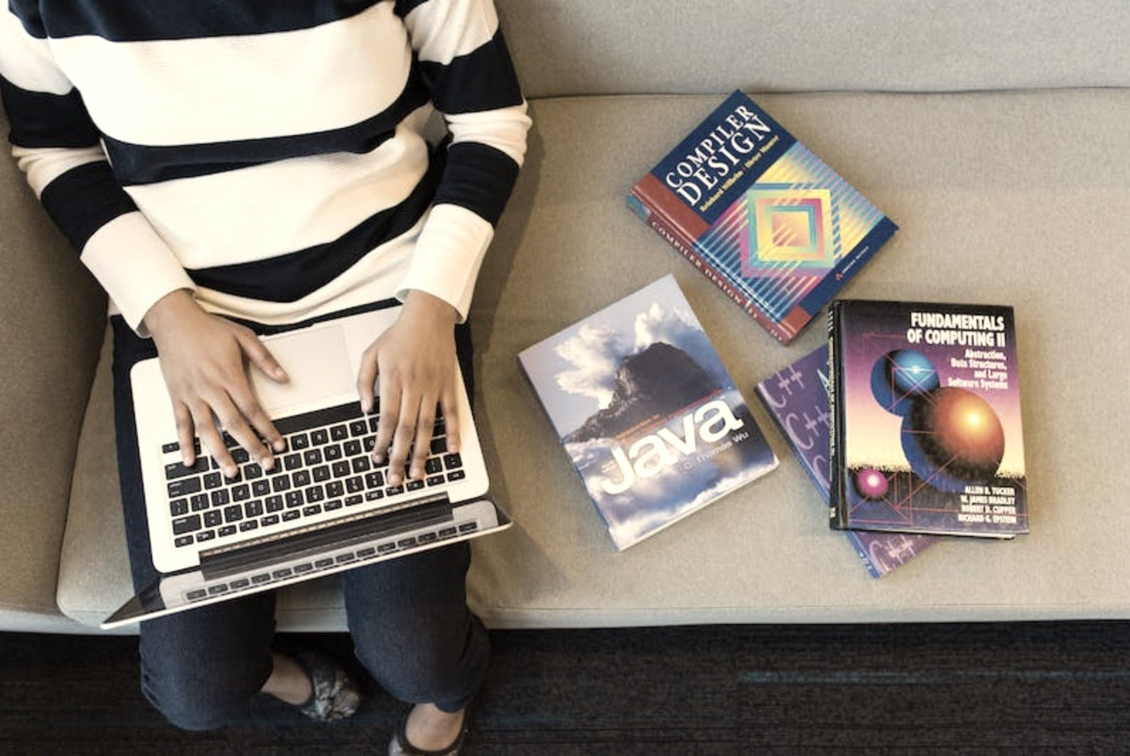 Женщина с ноутбуком на коленях; применены эффекты grayscale и sepia