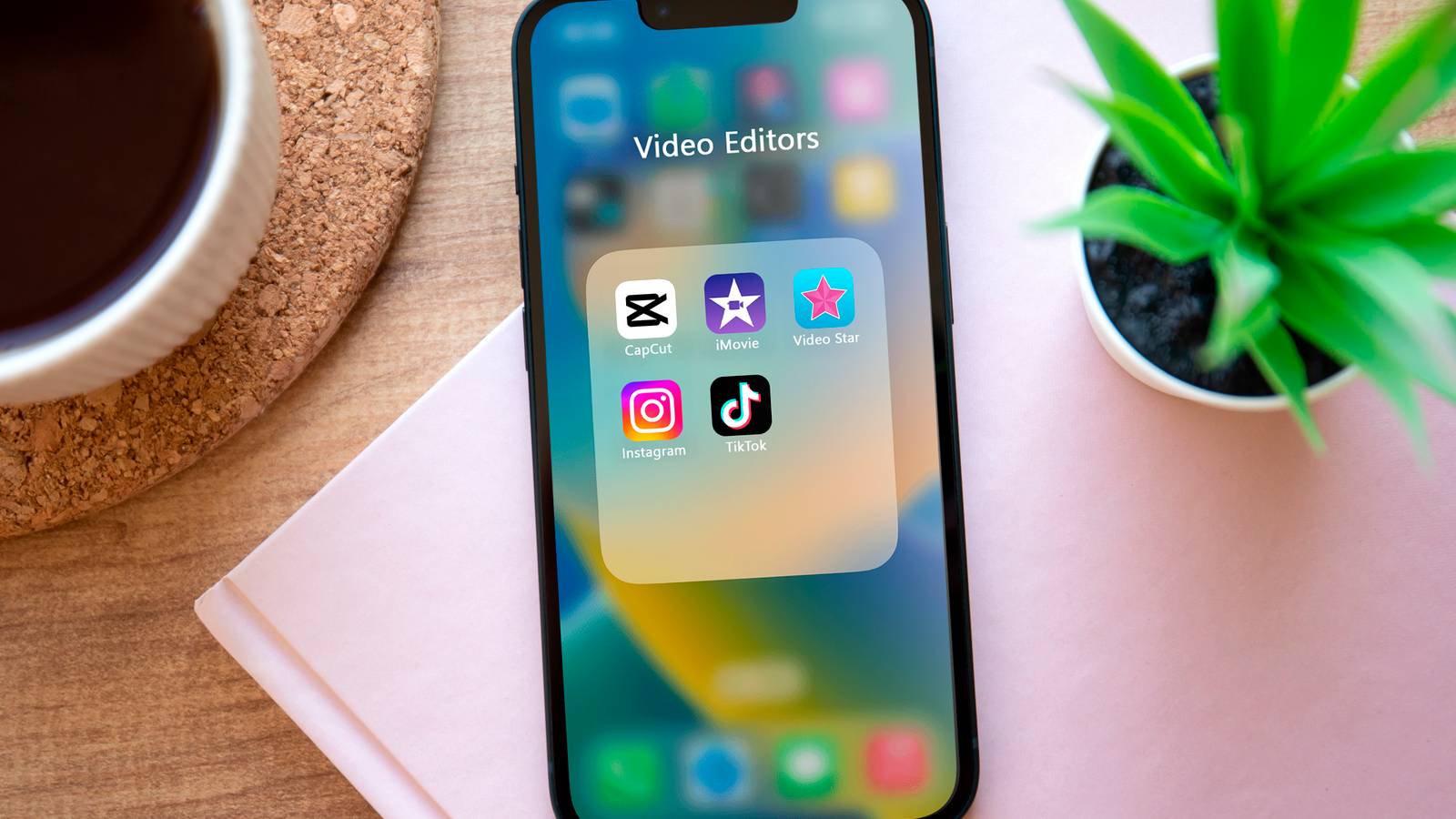 iPhone с папкой приложений для редактирования видео на экране.