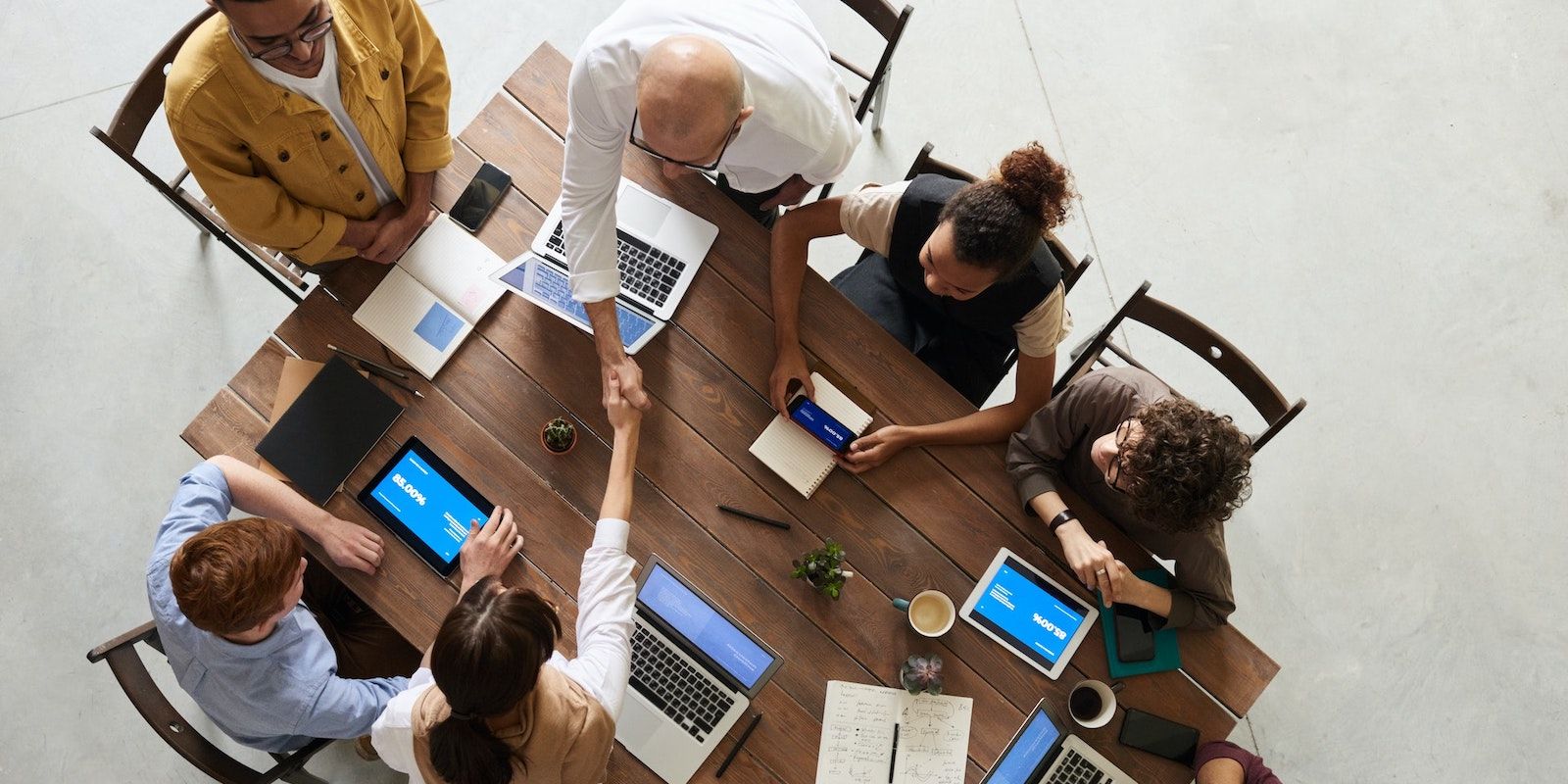 Люди обсуждают проект за столом с гаджетами