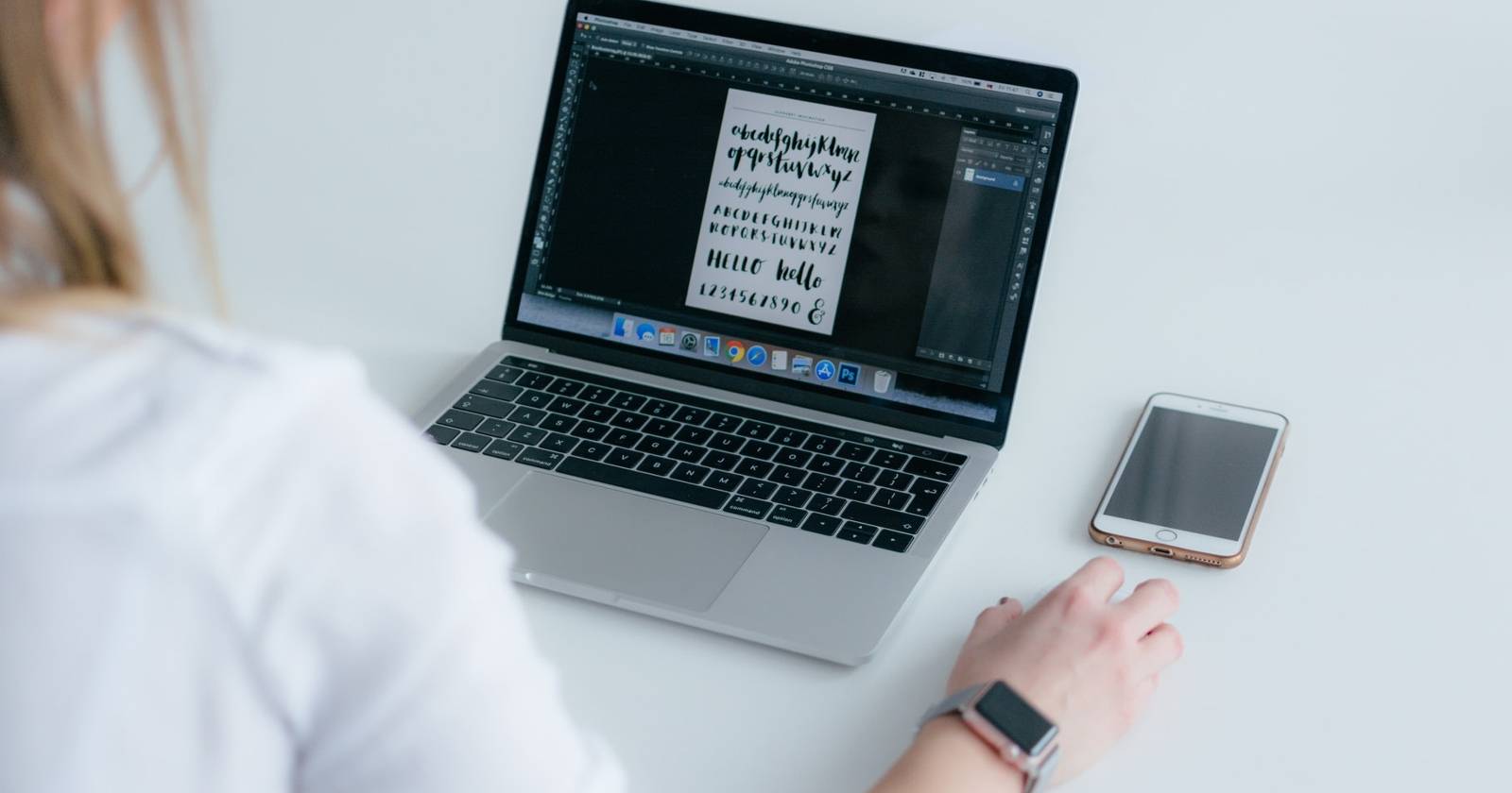 MacBook open on desk showing a custom font