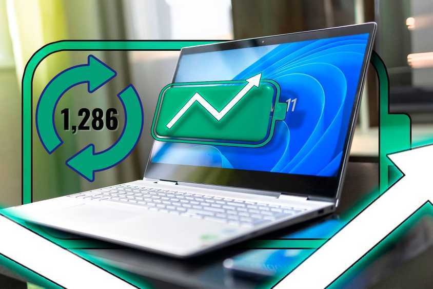 A laptop with Windows 11 showing a full battery icon with an upward arrow and cycle count